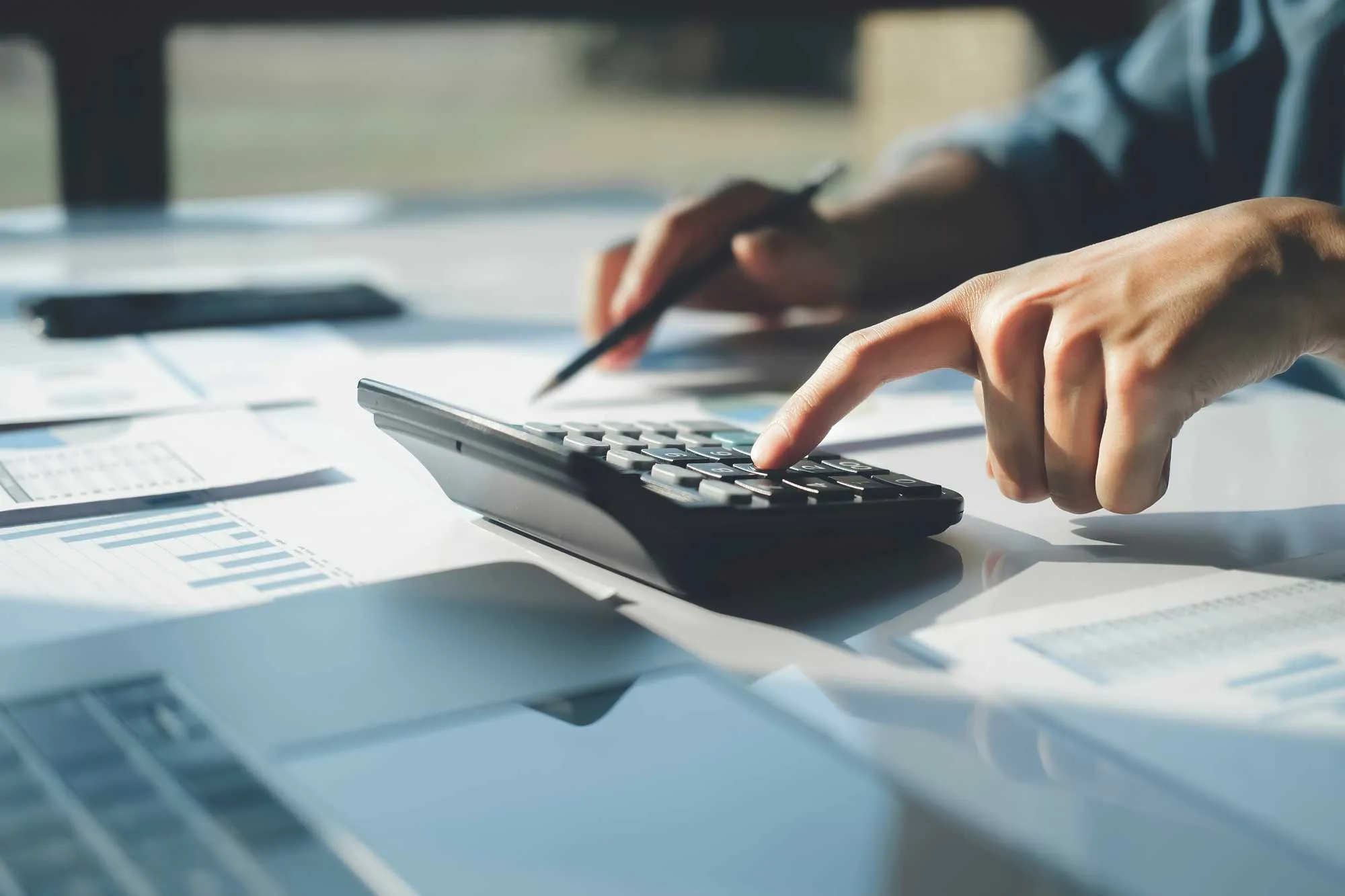 A person working through figures on a calculator